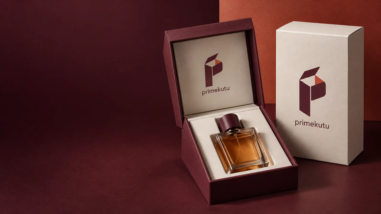 علبة عطر برغندية مفتوحة بجانب علبة عاجية مطبوعة بشعار برايم كوتو الجديد.